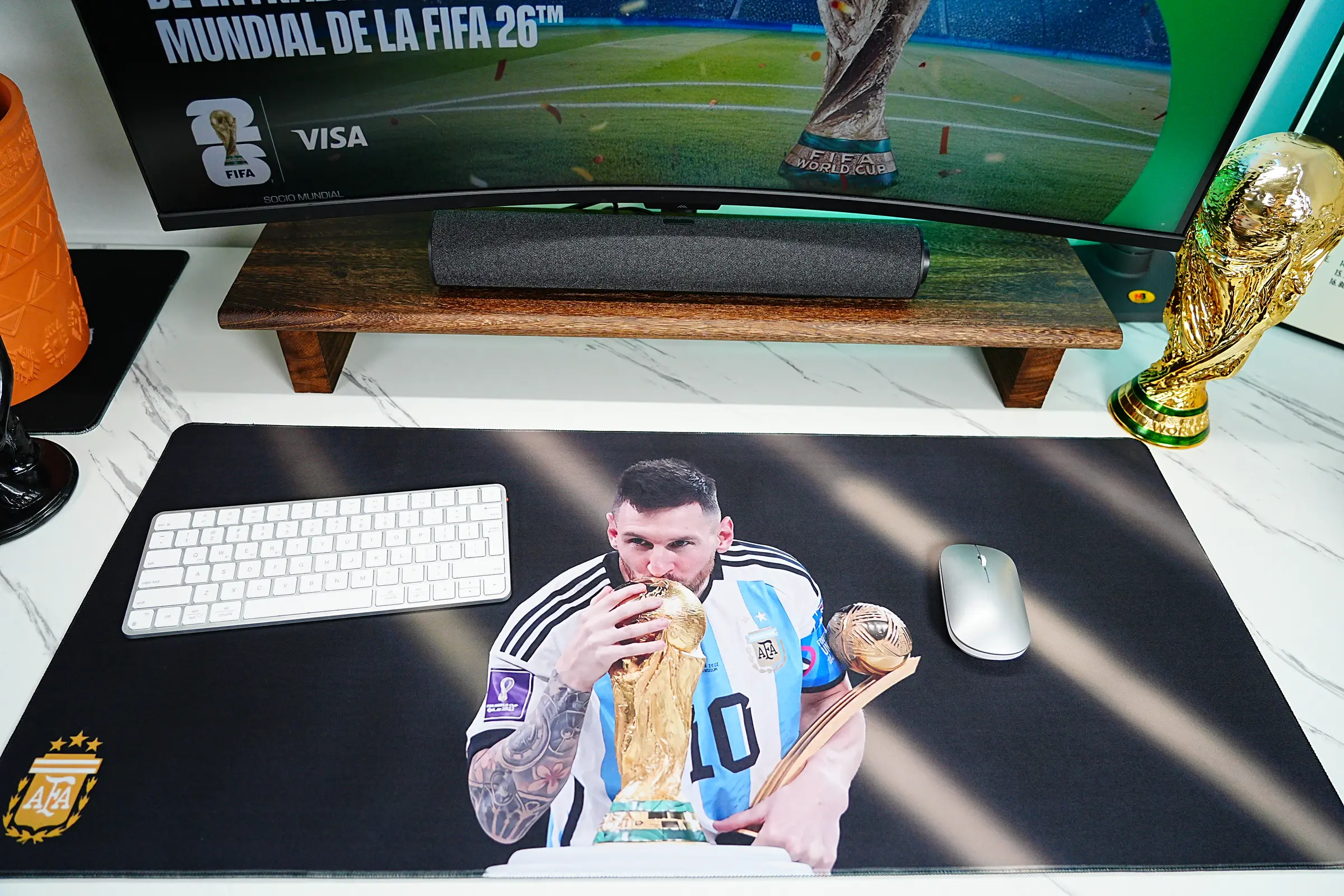 Iconic Mouse Mats shown in a Messi World Cup football desk setup with Argentina artwork, keyboard, mouse, and trophy decor.