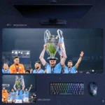 Kevin De Bruyne Man City 2023 Champions League Desk Mat featuring De Bruyne lifting the European Cup above his head with City teammates around him