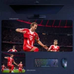 Harry Kane Bayern Match Action Desk Mat featuring Kane driving forward with Bayern teammates in a high-pressure stadium scene