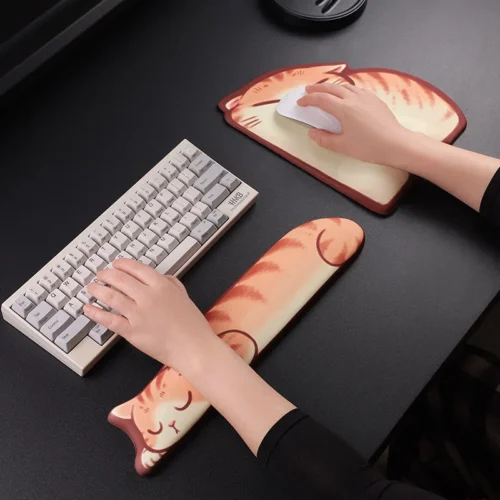 Sleepy Orange Tabby Wrist Rest Set in use, with hands typing on the keyboard rest and a hand on the mouse over the matching cat wrist-support pad.