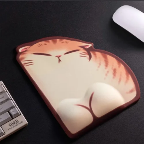 Sleepy Orange Tabby Wrist Rest Mouse Pad featuring a chubby sleeping tabby illustration with a raised wrist pillow on a matte black desk.