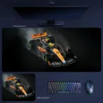 Lando Norris 2025 smoke charge desk mat with McLaren F1 artwork, dark background, rising tire smoke, and aggressive front-angle racing focus