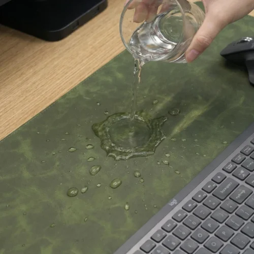 Water poured onto the leather section of the executive desk mat to show a surface that is easier to wipe clean during office use