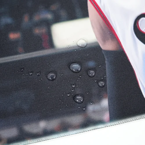 Close-up of water droplets on a spill-resistant basketball mouse mat surface, showing liquid beading above the printed fabric