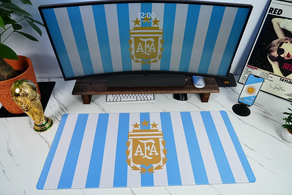Argentina Football Desk Mat World Cup Setup Argentina Football Desk Mat shown in a blue-white desk setup with matching monitor wallpaper, World Cup trophy display, phone artwork, keyboard, and mouse