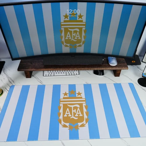 Argentina Football Desk Mat World Cup Setup Argentina Football Desk Mat shown in a blue-white desk setup with matching monitor wallpaper, World Cup trophy display, phone artwork, keyboard, and mouse