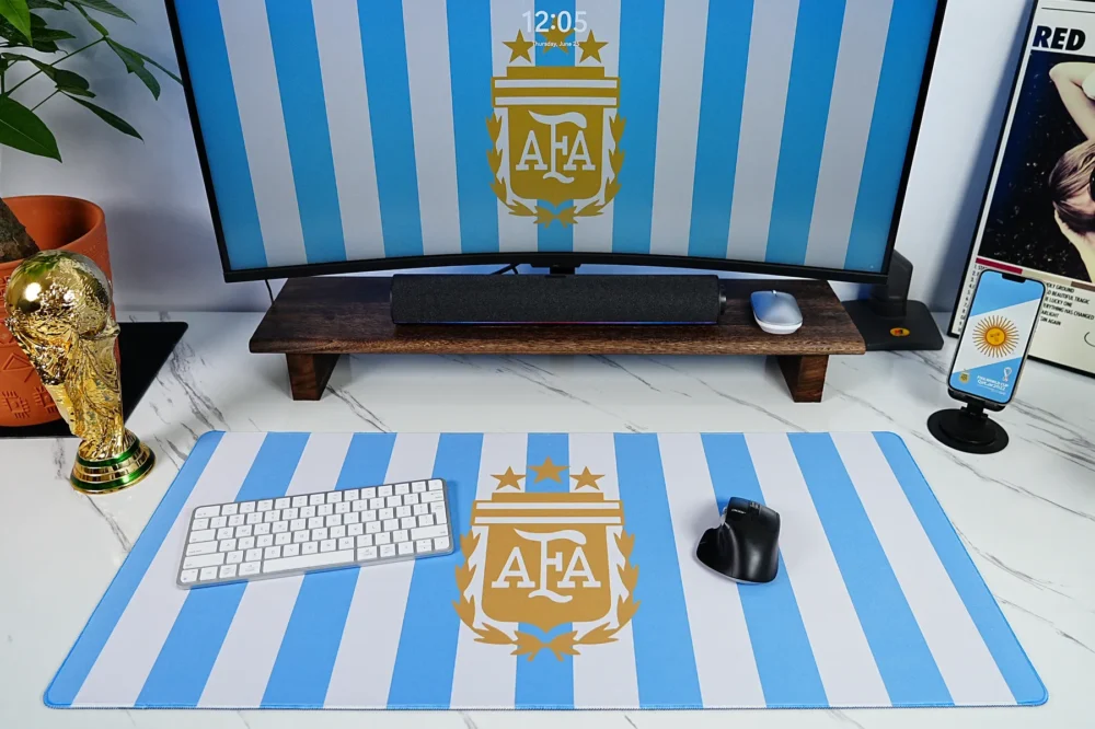 Argentina Keyboard Mouse Desk Mat Setup Argentina football desk mat used with keyboard and mouse, matching monitor wallpaper, World Cup trophy display, and visible blue-white crest artwork