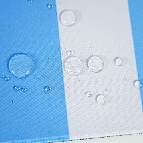 Spill Resistant Argentina Desk Mat Surface Spill-resistant Argentina football desk mat surface with water droplets on blue-white fabric and stitched edge for easier cleanup