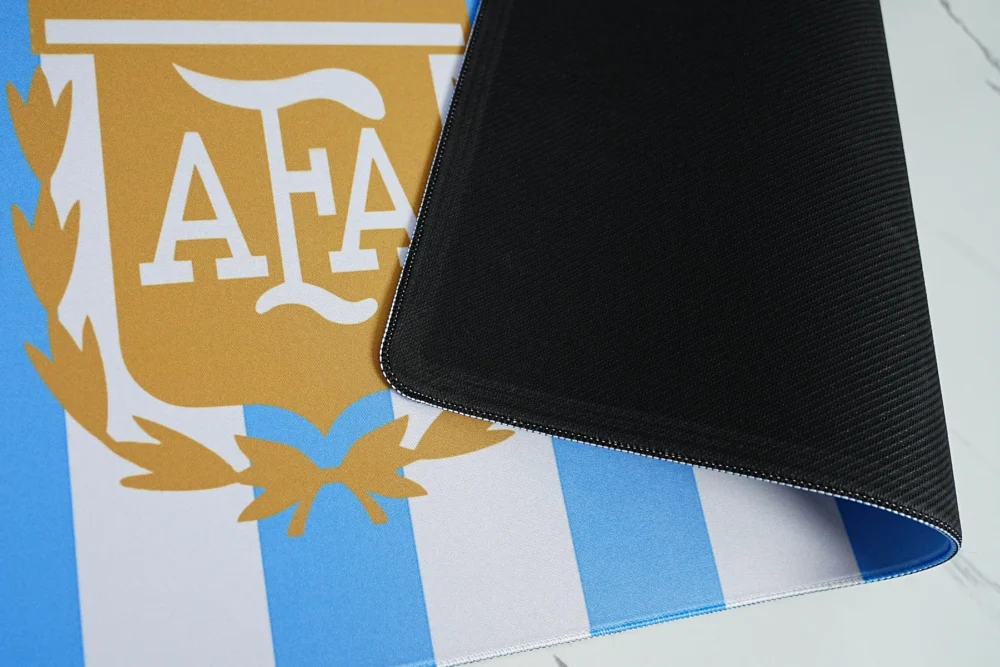 Anti Slip Argentina Football Desk Mat Base Argentina football desk mat lifted to show black anti-slip rubber base, flexible 4mm structure, stitched edge, and blue-white printed top