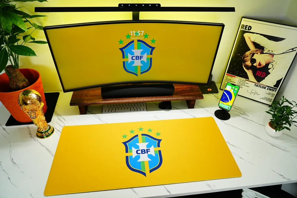 Brazil Football Team Desk Mat shown in a yellow fan desk setup with matching monitor wallpaper, phone wallpaper, and World Cup trophy decor