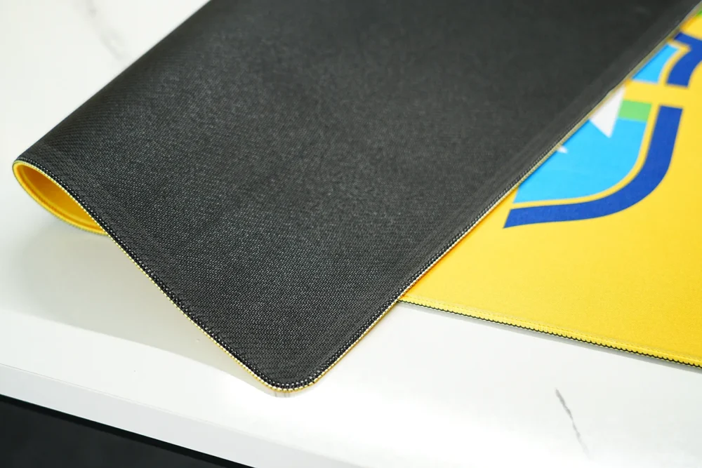 Anti-slip rubber base of a football desk mat with stitched edges and flexible 4mm construction for stable desk use