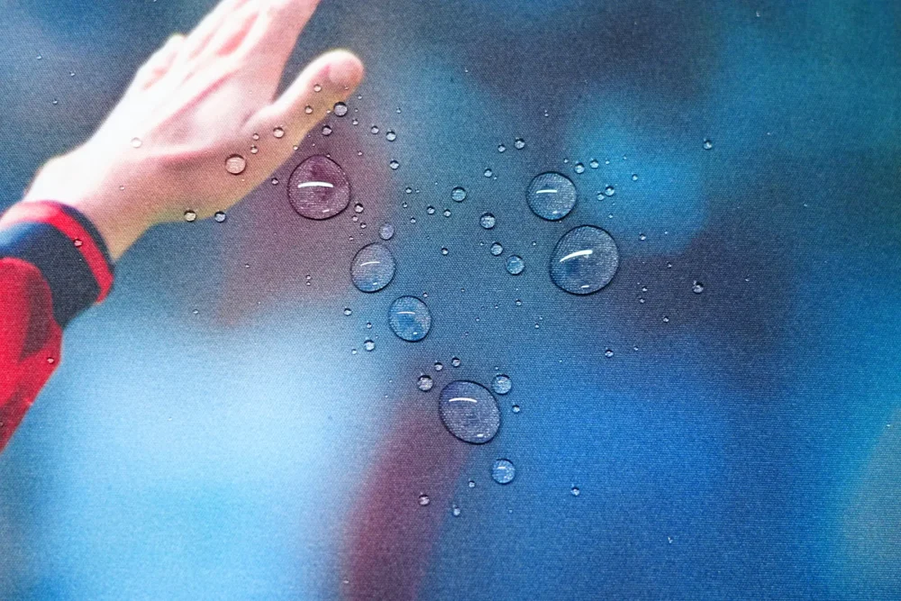 Water droplets resting on the David Beckham desk mat surface, showing a spill-resistant fabric that keeps small liquid spills on the surface for easier cleanup