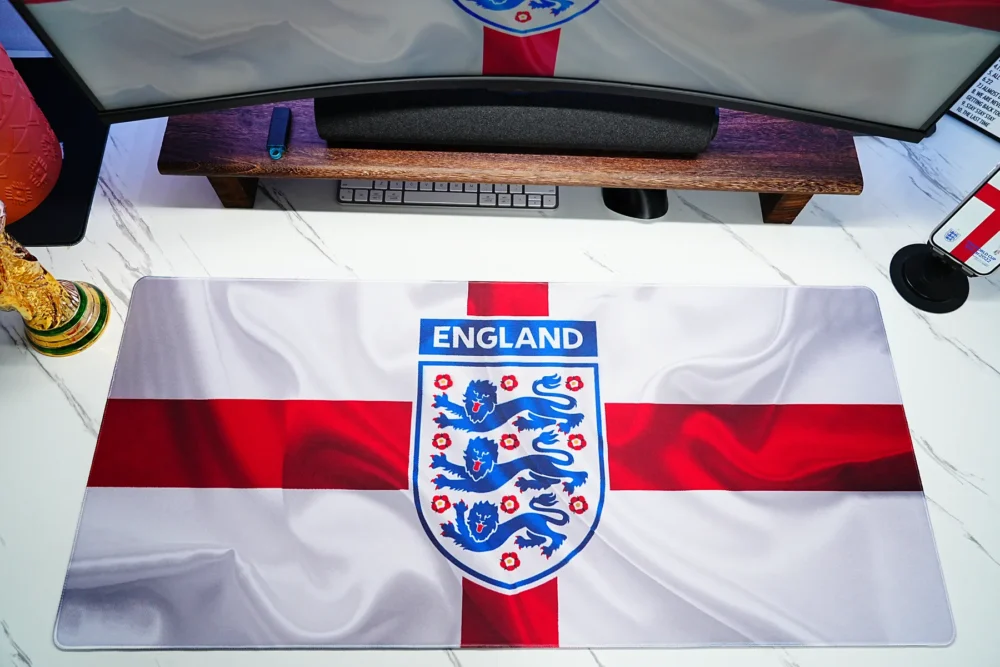 England football desk mat placed under a monitor to show real desk coverage, clear flag artwork, and usable workspace layout