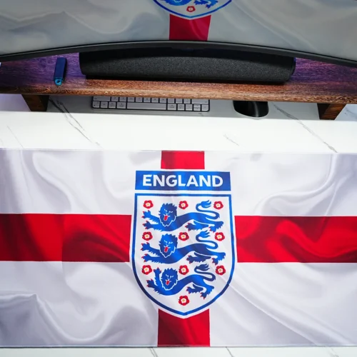 England football desk mat placed under a monitor to show real desk coverage, clear flag artwork, and usable workspace layout