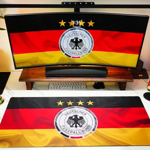 Germany Football Team Desk Mat shown in a full fan desk setup with matching monitor wallpaper, World Cup trophy decor, and football-themed workspace