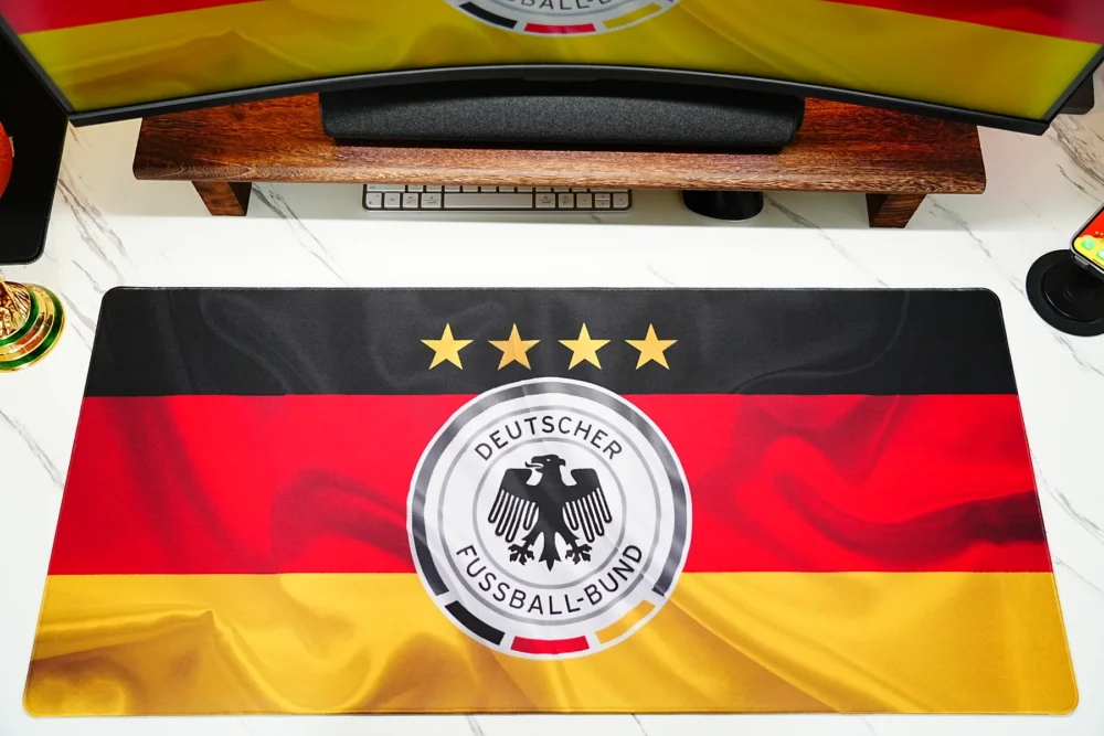 Germany football desk mat matched with a monitor wallpaper to create a unified football fan workspace
