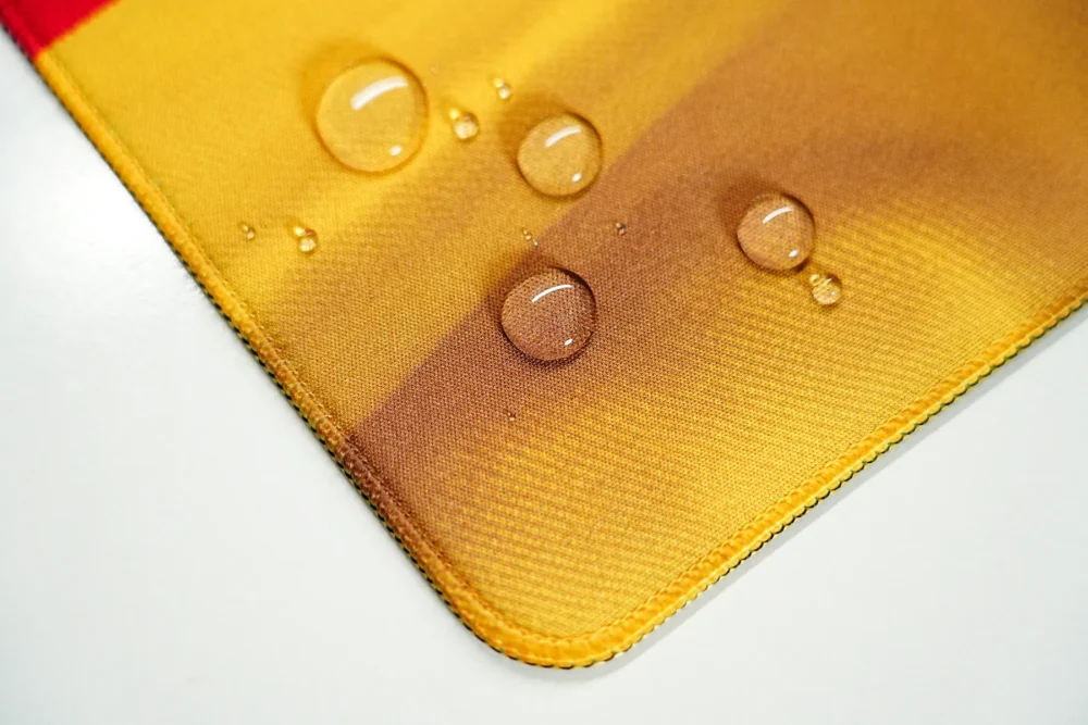 Water drops sitting on the Germany football desk mat surface with stitched edges for spill resistance and edge protection
