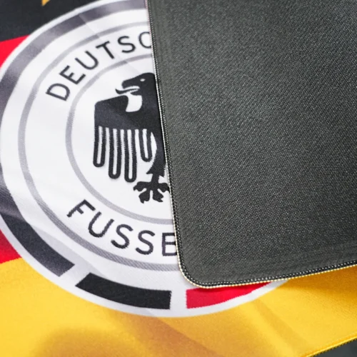 Germany football desk mat flipped to show black anti-slip rubber base and printed fabric surface comparison