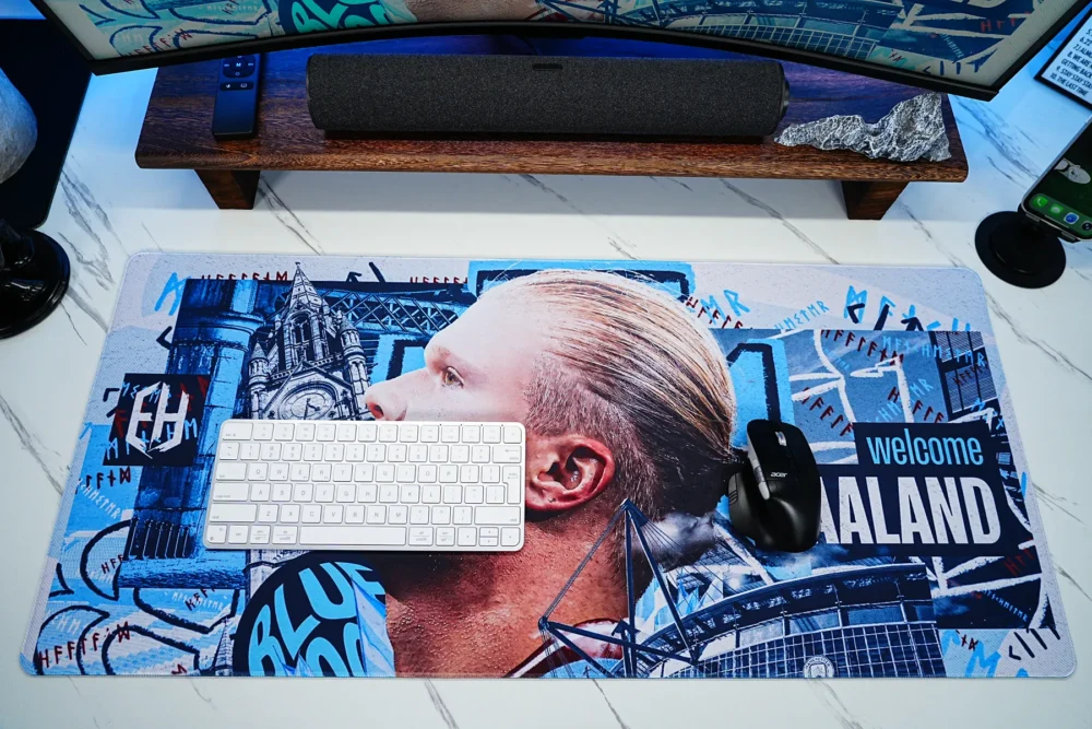 Haaland desk mat shown with a keyboard and mouse, demonstrating that the artwork remains visible while providing comfortable movement space for everyday use.