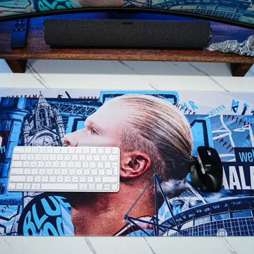 Haaland desk mat shown with a keyboard and mouse, demonstrating that the artwork remains visible while providing comfortable movement space for everyday use.