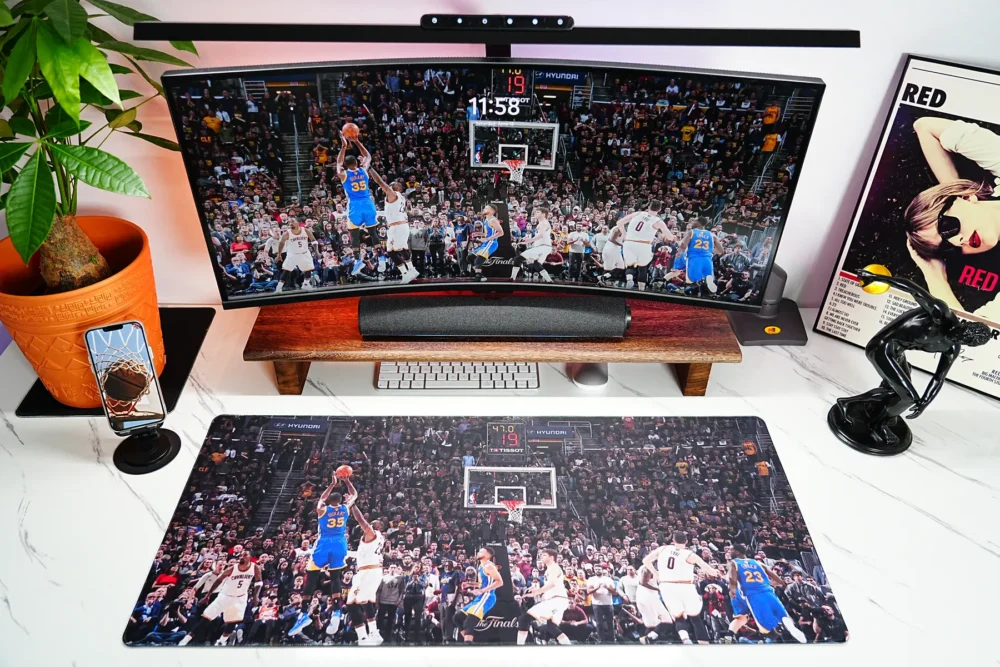 Warriors Finals basketball desk mat shown with a wide curved monitor, matching Durant wallpaper, and a clean fan desk setup