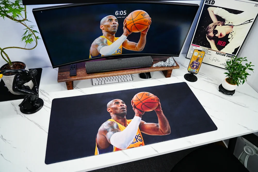 Kobe Bryant mouse pad shown in a full desk setup with monitor, keyboard, phone, and basketball fan decor