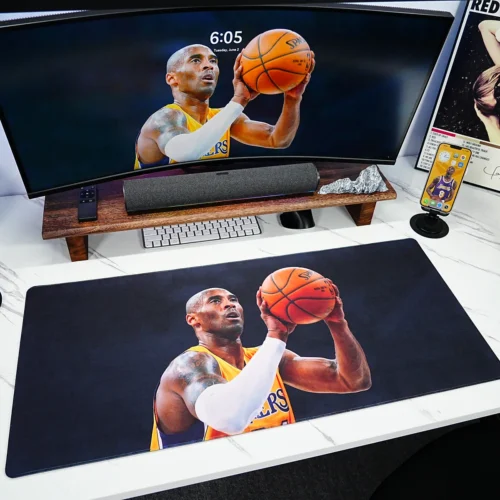 Kobe Bryant mouse pad shown in a full desk setup with monitor, keyboard, phone, and basketball fan decor