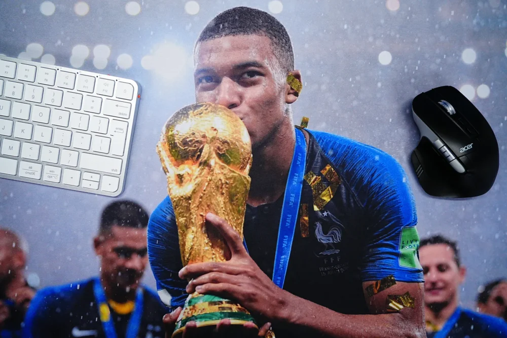 Close-up view of Mbappe World Cup mouse pad showing clear trophy artwork beside keyboard and mouse for daily use