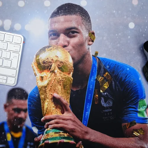 Close-up view of Mbappe World Cup mouse pad showing clear trophy artwork beside keyboard and mouse for daily use