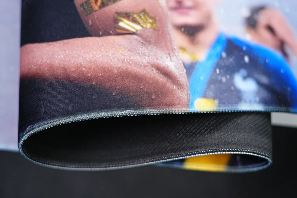 Mbappe mouse pad bent to show stitched edges, flexible surface, 4mm thickness, and textured anti-slip rubber base