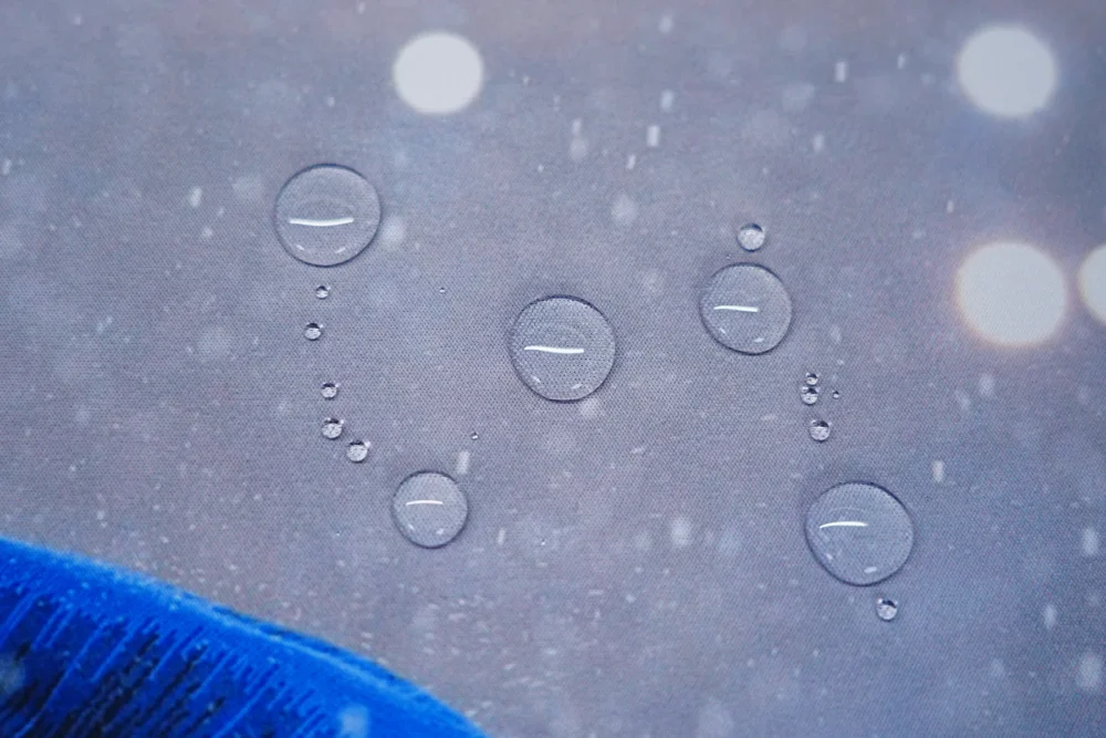 Close-up of Mbappe mouse pad spill-resistant cloth surface showing water droplets staying on top instead of soaking in