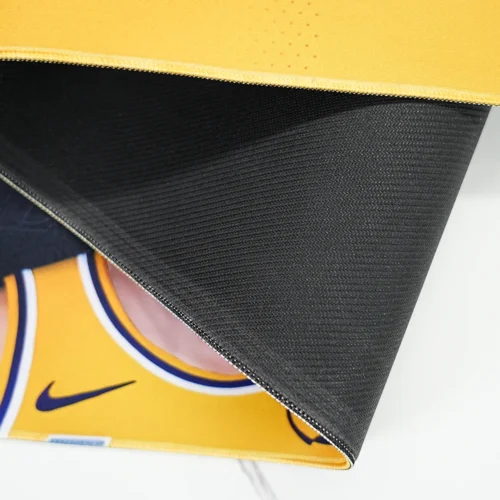 Close-up of the desk pad underside showing textured anti-slip rubber base and stitched edge for better grip and durability