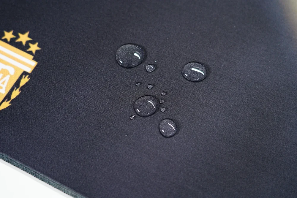 Messi Mouse Pad Spill-Resistant Cloth Surface Water drops resting on the Messi mouse pad cloth surface, showing spill resistance for easier daily desk protection
