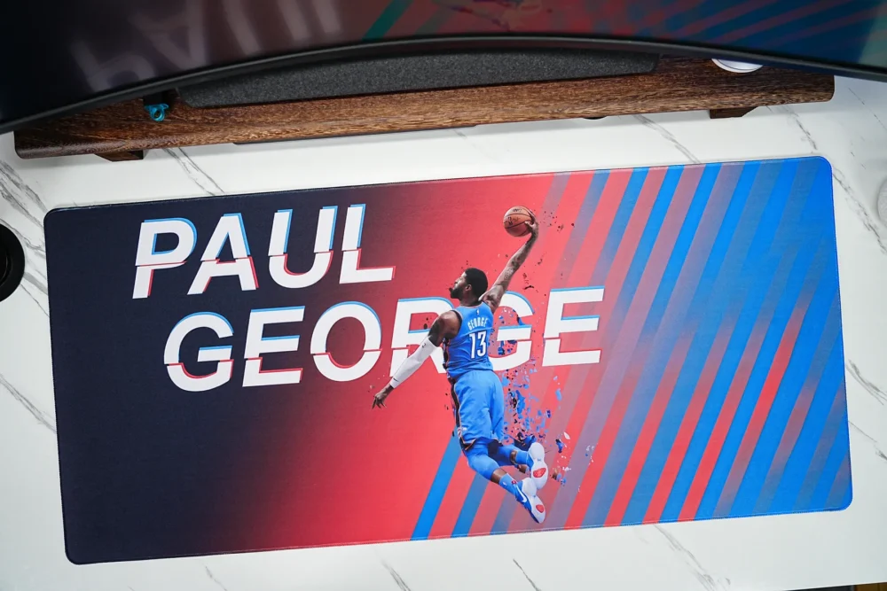 Wide Paul George basketball desk mat placed under a monitor to show broad desktop coverage and clear artwork