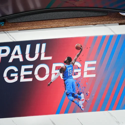Wide Paul George basketball desk mat placed under a monitor to show broad desktop coverage and clear artwork