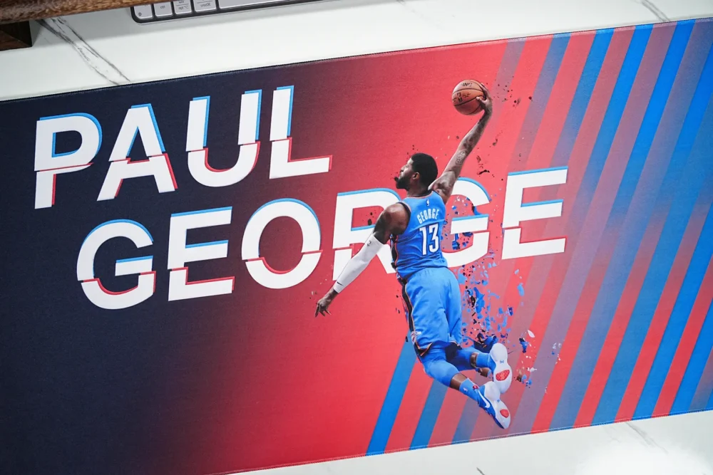 Close-up of Paul George mouse pad artwork showing vivid blue orange color, sharp print detail, and fabric texture