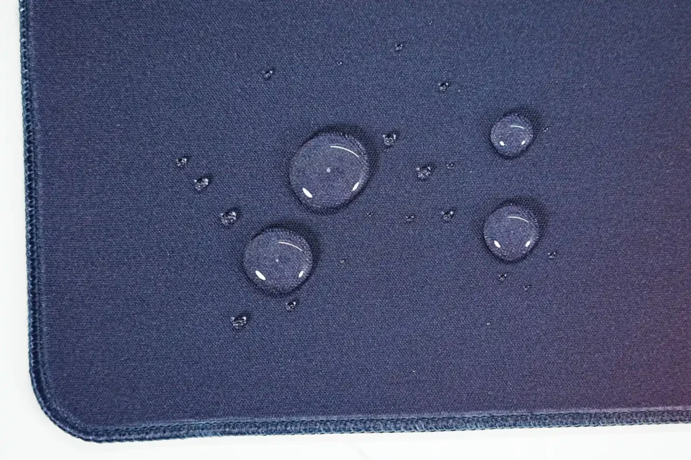 Water-resistant basketball mouse pad surface with water beads staying on top for easier spill cleanup