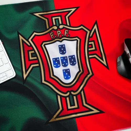 Portugal football desk mat with mouse on low-friction surface beside a keyboard for smooth movement and controlled cursor use