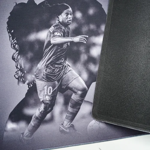 Ronaldinho Barcelona desk mat lifted to show the anti-slip rubber base and stitched edge for stable placement and edge protection
