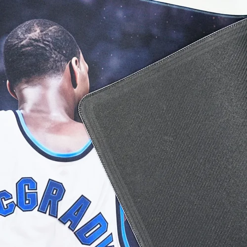 Gaming mouse pad lifted to show 4mm textured rubber base that helps grip the desk during quick mouse movement