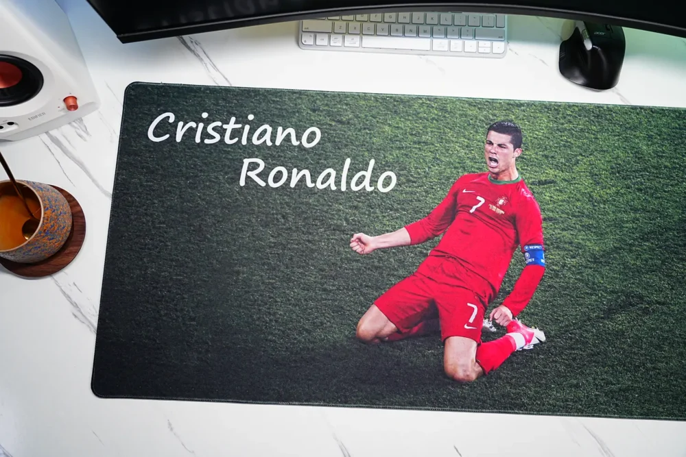 Close-up of Cristiano Ronaldo mouse pad showing Portugal knee-slide artwork, name lettering, grass texture and stitched edge