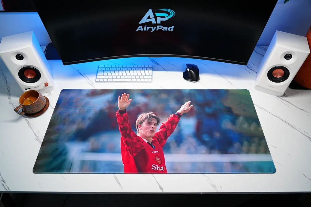 David Beckham tribute football desk mat in a desktop setup with a keyboard, mouse and speakers