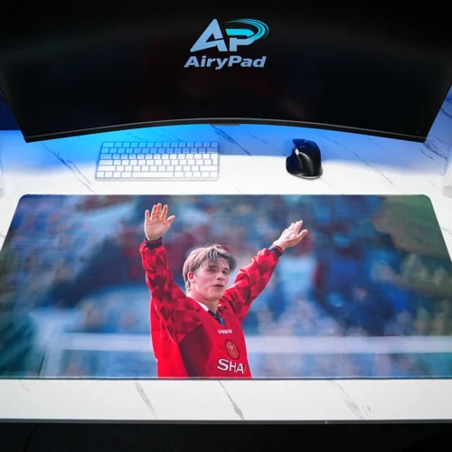 David Beckham tribute football desk mat in a desktop setup with a keyboard, mouse and speakers