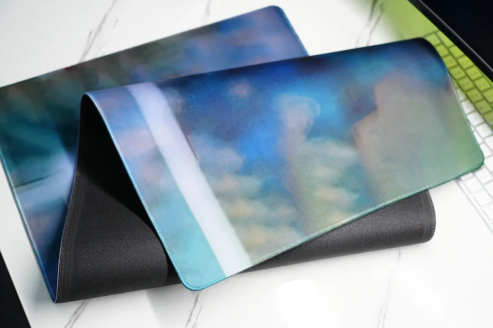 Folded David Beckham desk mat showing the flexible natural rubber base and reinforced stitched edge