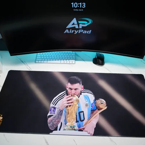 Overhead view of Lionel Messi Argentina 2022 World Cup desk mat with monitor, keyboard, mouse, speakers and trophy