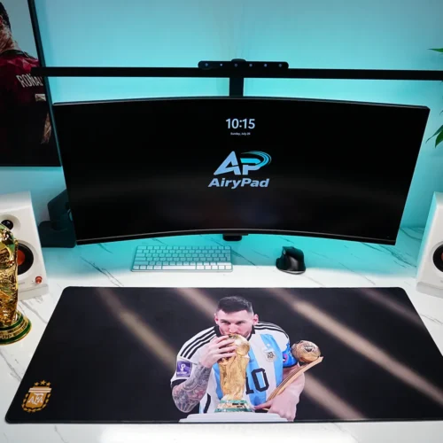 Front view of Lionel Messi Argentina World Cup desk mat in a wide desktop setup with monitor and speakers