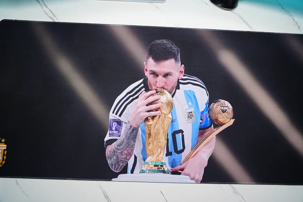 Close-up of Lionel Messi kissing the World Cup trophy on the printed mouse pad surface