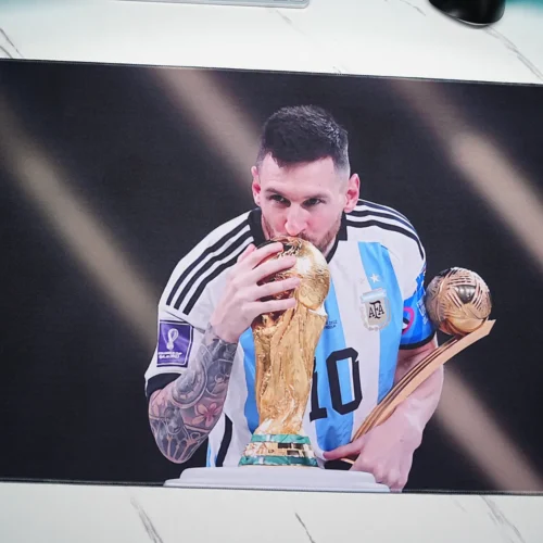 Close-up of Lionel Messi kissing the World Cup trophy on the printed mouse pad surface