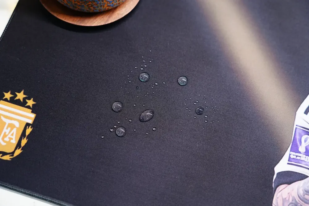 Water drops beading on the Lionel Messi Argentina World Cup desk mat spill-resistant cloth surface