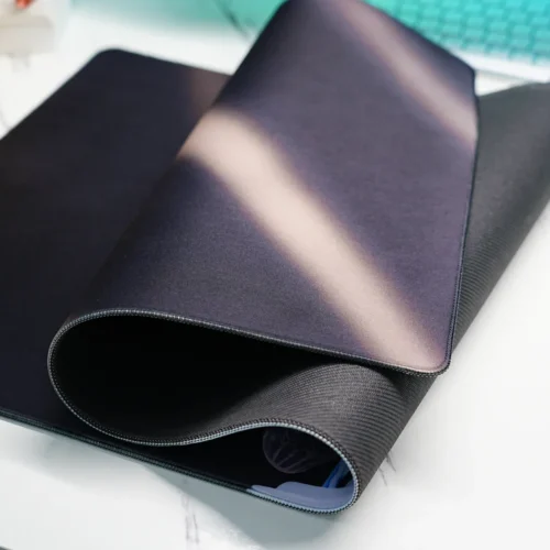 Rolled Lionel Messi World Cup desk mat showing stitched edge and textured non-slip rubber base